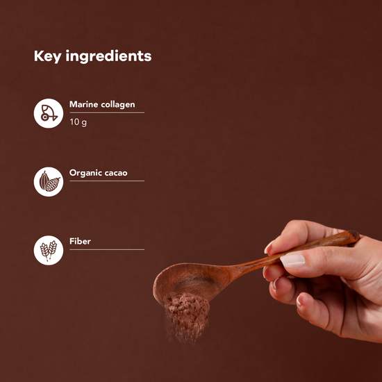 Chocolate collagen powder in a glass with a spoon on the table