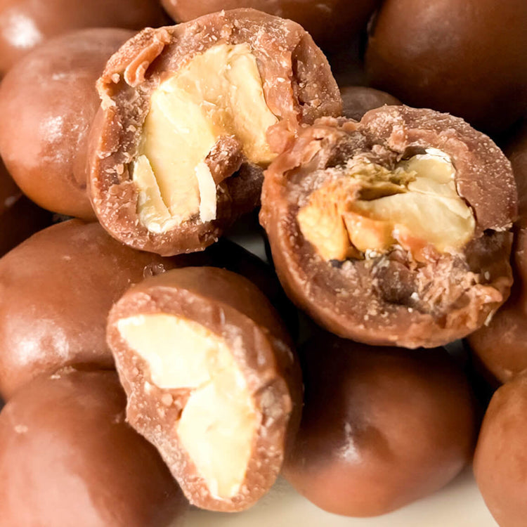 Karü chocolate-covered cashews without packaging, with some split in half revealing the cashew inside.