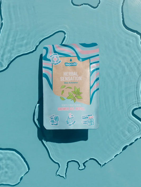 A shampoo refill package labeled 'Healthy Herbs' floating on a water surface with a blue background.
